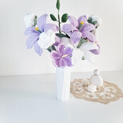grand bouquet de lys au crochet lilas et blancs avec boutons blancs et feuillage vert dans un vase blanc